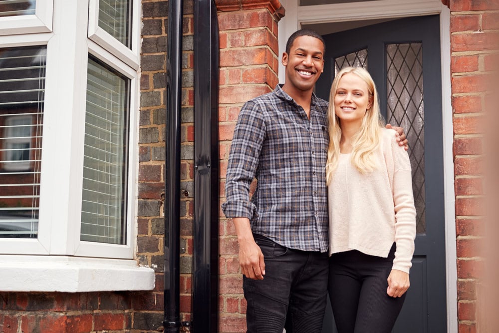 Couple standing outside of home